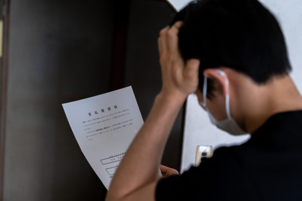 書類を手に頭を抱える男性