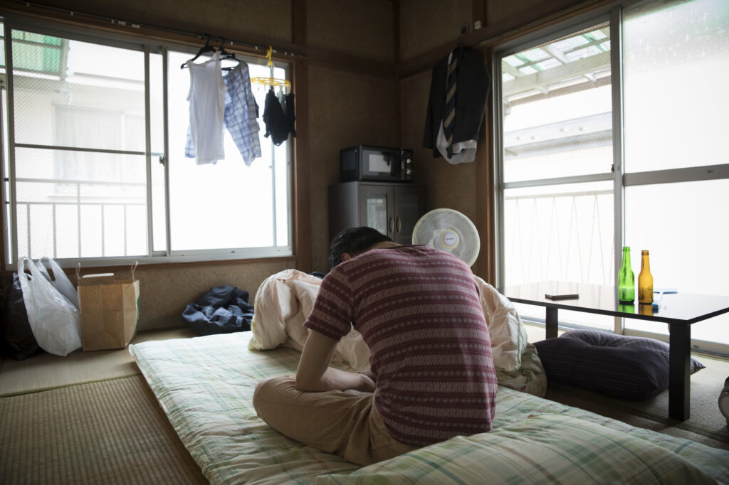 和室でうつむいて座り込む男性