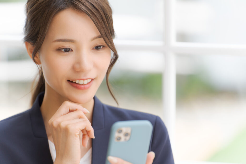 スマートフォンで相談窓口を調べる女性