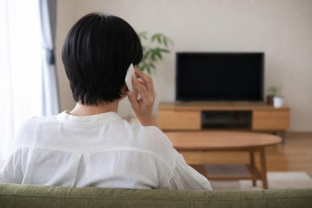 相談の電話をかける人の後ろ姿のイメージ