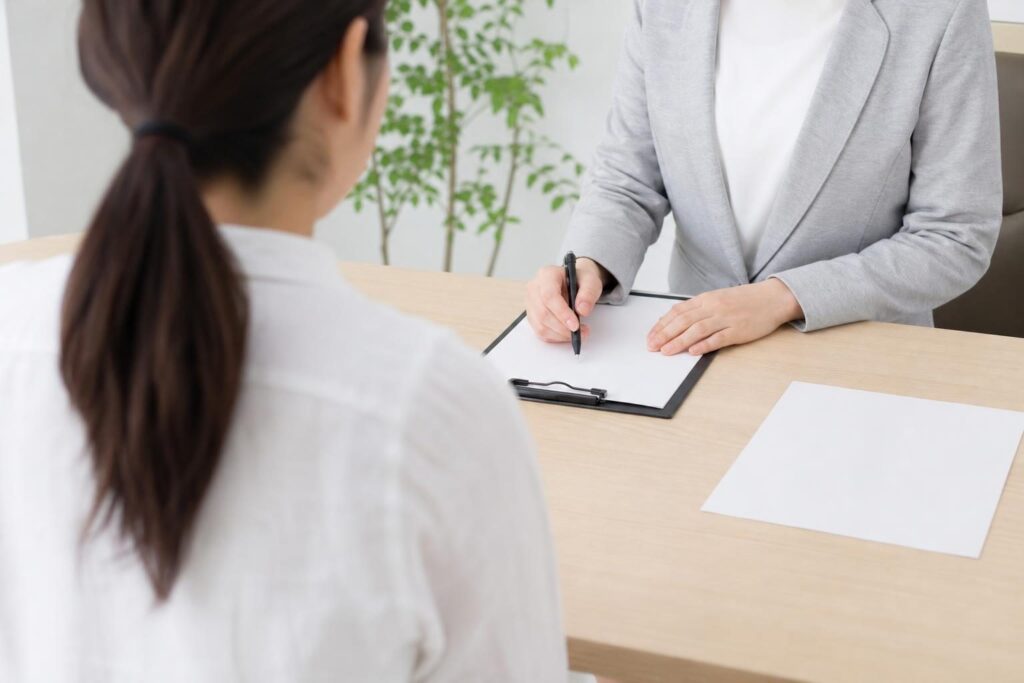 窓口で相談する人の後ろ姿