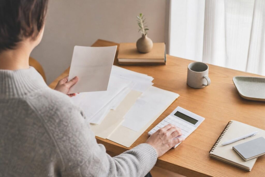 書類を整理する手元、家計の相談イメージ