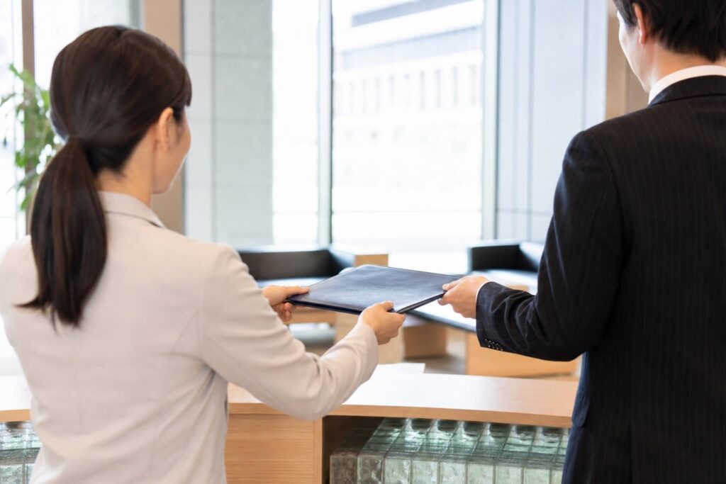 転職先へ書類を引き継ぐ会社員たちの後ろ姿