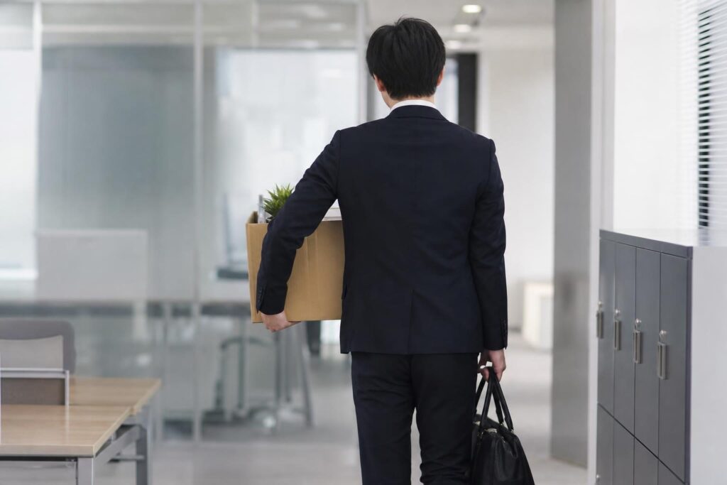 段ボール箱を持ち会社を後にする後ろ姿