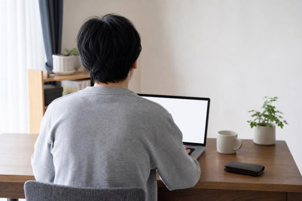 パソコン画面を見ながら考える後ろ姿