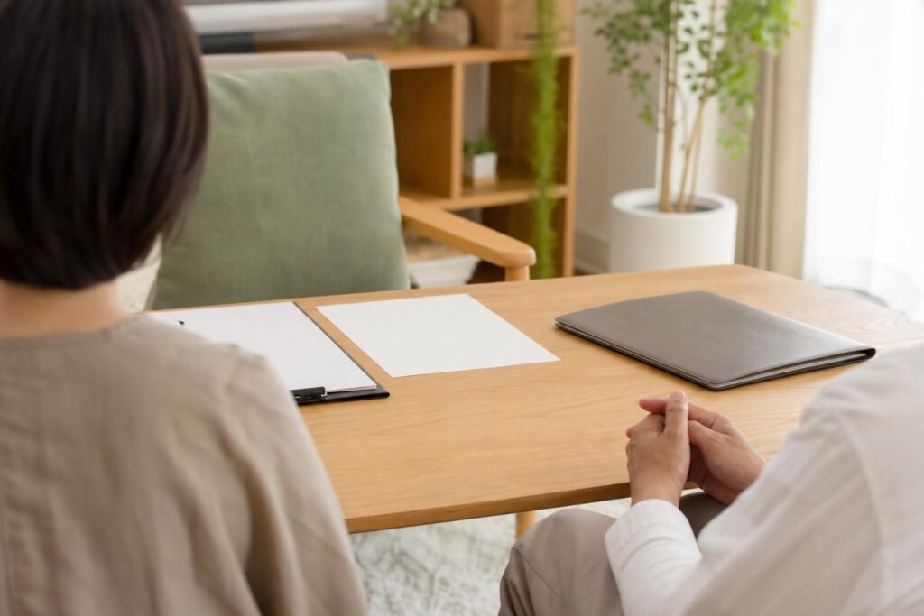 相談室で向き合う二人の後ろ姿