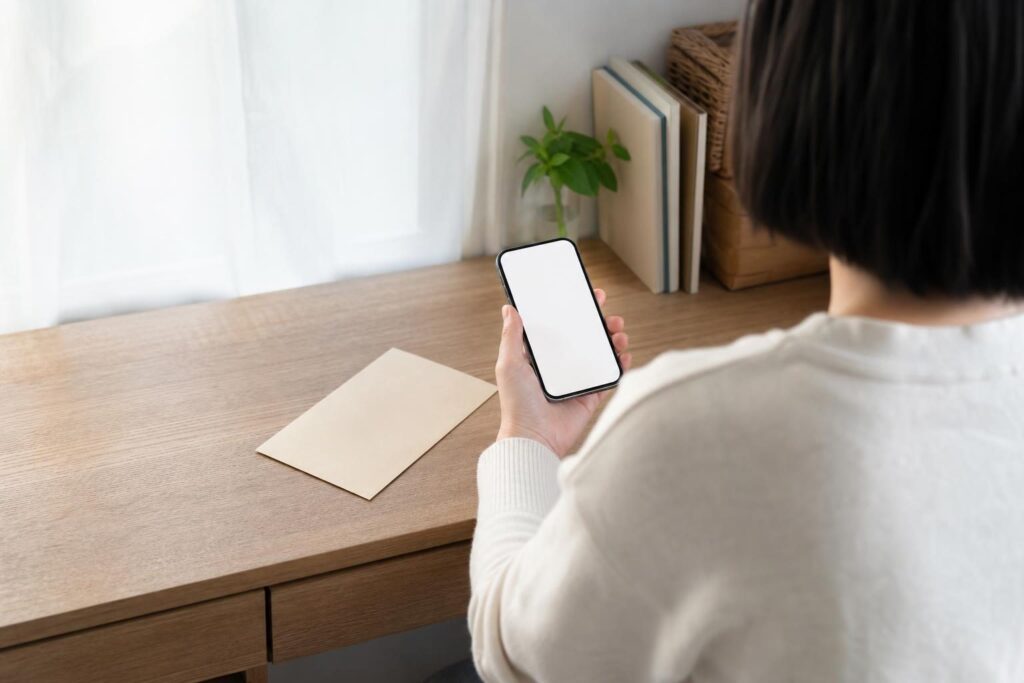 自宅の机で書類を確認する人物の後ろ姿