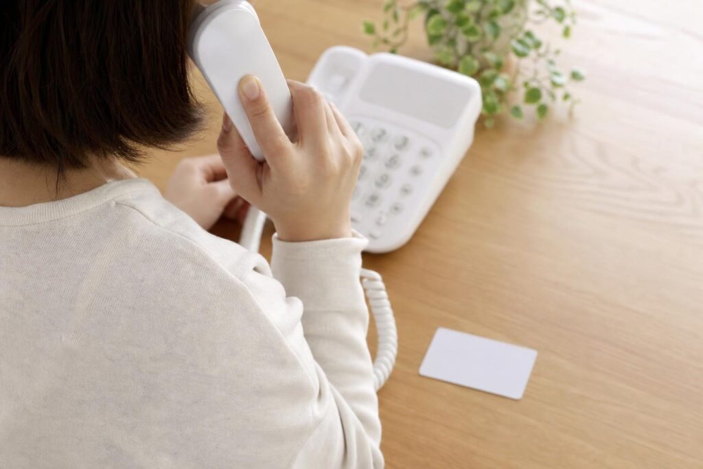 電話をかけながらカードを確認する人の手元