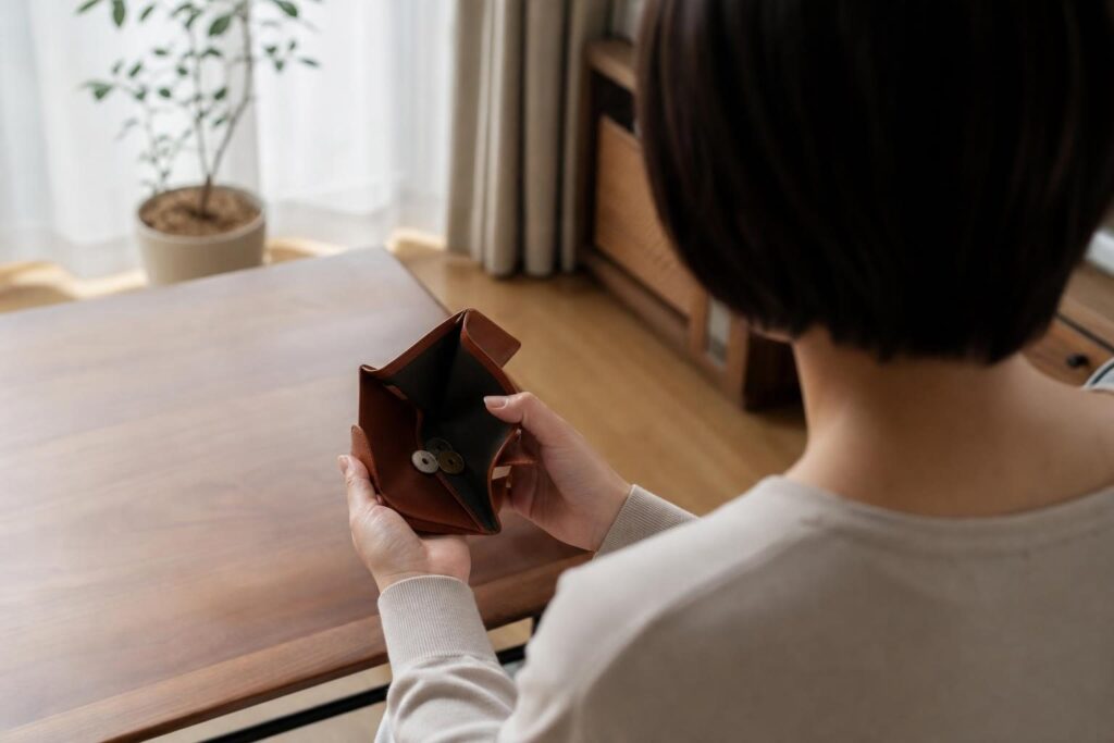 財布を開いて確認する人物の後ろ姿
